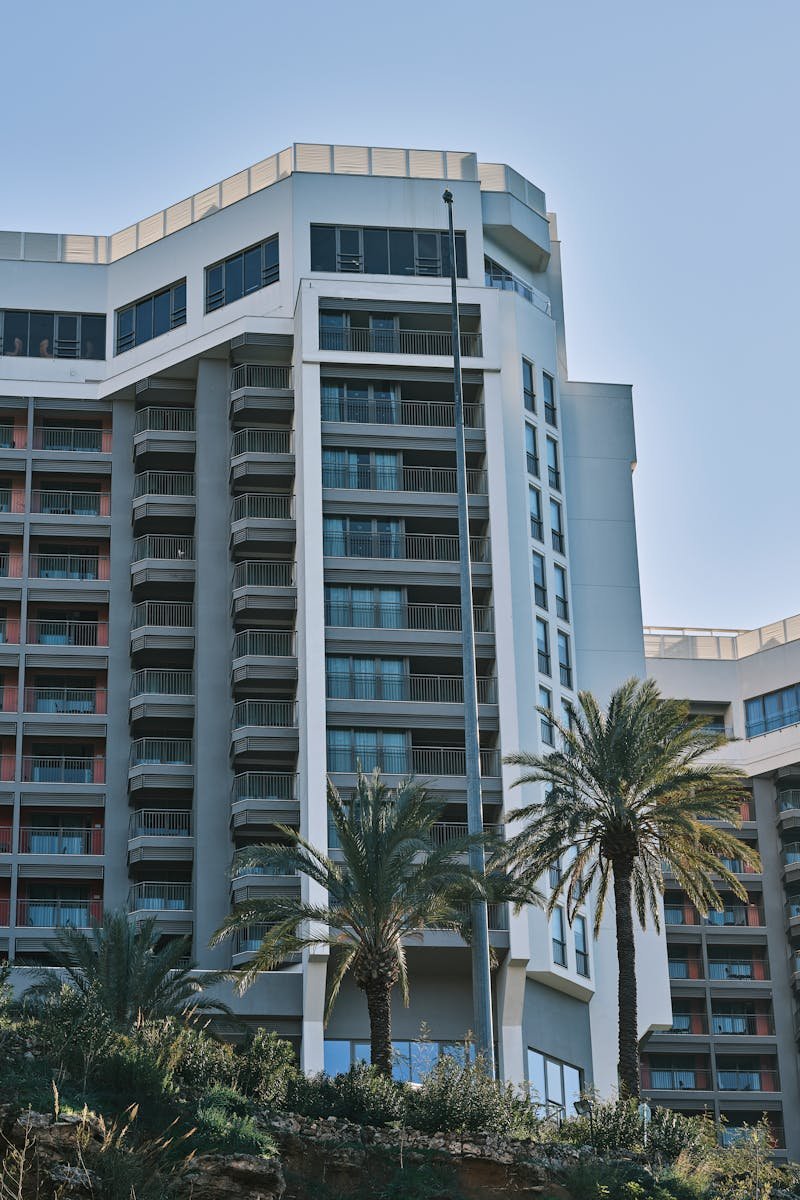Contemporary hotel building exterior in Antalya, Turkey, featuring modern architecture and palm trees.